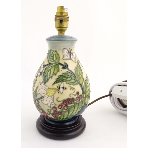 155 - A Moorcroft table lamp base decorated in the Strawberry Plant and Butterfly pattern, on a turned woo... 