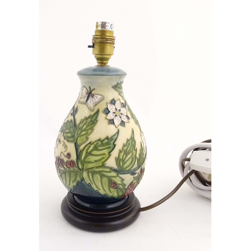 155 - A Moorcroft table lamp base decorated in the Strawberry Plant and Butterfly pattern, on a turned woo... 