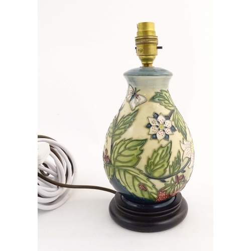 155 - A Moorcroft table lamp base decorated in the Strawberry Plant and Butterfly pattern, on a turned woo... 