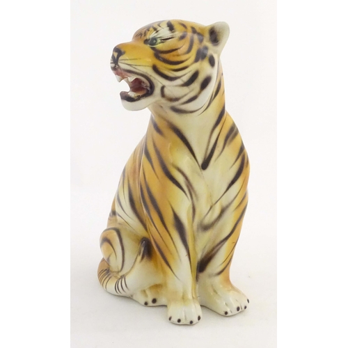 182 - A 20thC Continental model of a seated tiger. Marked under C. L. F. Faiancas Alcobaca Portugal. Appro... 