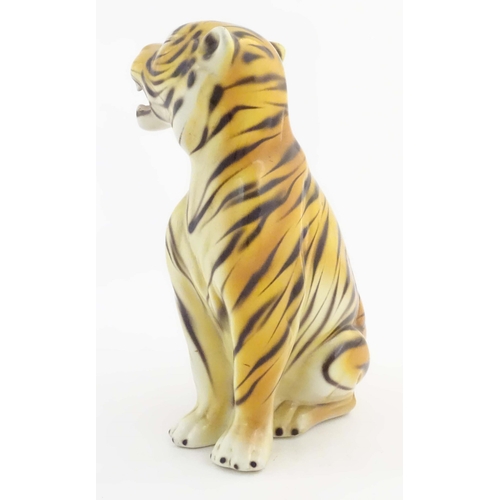 182 - A 20thC Continental model of a seated tiger. Marked under C. L. F. Faiancas Alcobaca Portugal. Appro... 