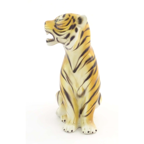 182 - A 20thC Continental model of a seated tiger. Marked under C. L. F. Faiancas Alcobaca Portugal. Appro... 