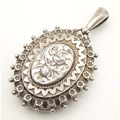 622 - A Victorian silver locket of pendant form with engraved decoration. hallmarked Birmingham 1886. Appr... 