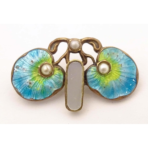 626 - An Art Nouveau brooch formed as a stylised butterfly and set with enamel and mother of pearl detail.... 