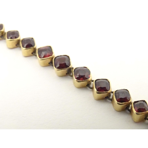 628 - A yellow metal bracelet set with 10 garnets. Approx 7 1/2