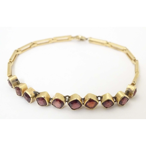 628 - A yellow metal bracelet set with 10 garnets. Approx 7 1/2