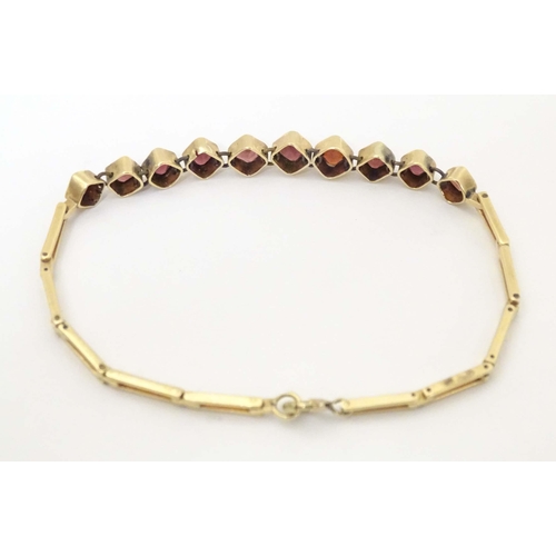 628 - A yellow metal bracelet set with 10 garnets. Approx 7 1/2