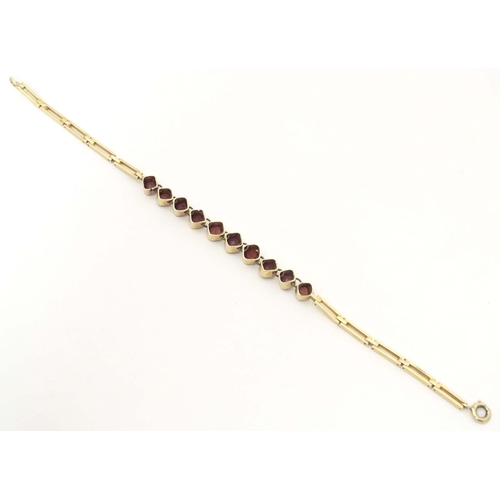 628 - A yellow metal bracelet set with 10 garnets. Approx 7 1/2