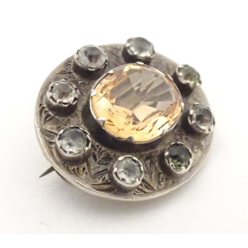 635 - A white metal brooch set with central citrine bordered by white stones. 1