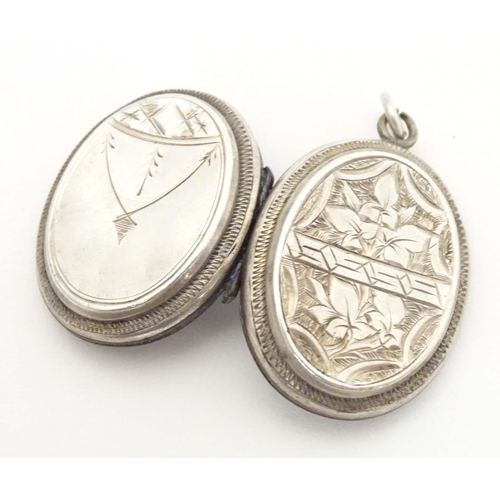 638 - A white metal pendant locket of oval form with foliate decoration 1 1/4