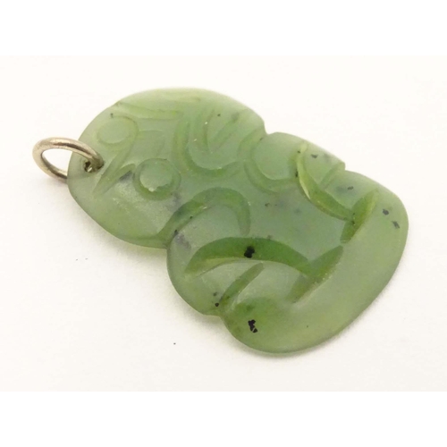 643 - A New Zealand nephrite Maori pendant with carved detail. Approx 1 1/42 long