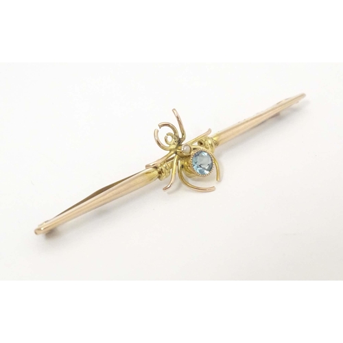 647 - A 9ct gold bar brooch set with spider to centre having a blue stone body 2 1/2