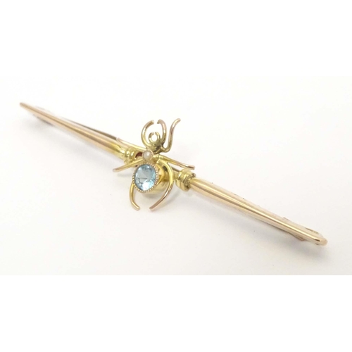 647 - A 9ct gold bar brooch set with spider to centre having a blue stone body 2 1/2