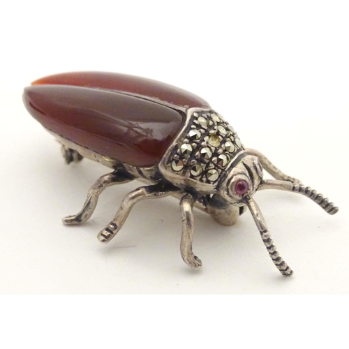 652 - A silver and white metal brooch formed as a beetle, with red stone eyes, marcasite detail and garnet... 