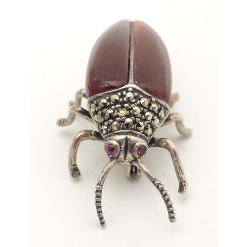 652 - A silver and white metal brooch formed as a beetle, with red stone eyes, marcasite detail and garnet... 