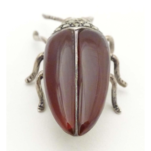 652 - A silver and white metal brooch formed as a beetle, with red stone eyes, marcasite detail and garnet... 