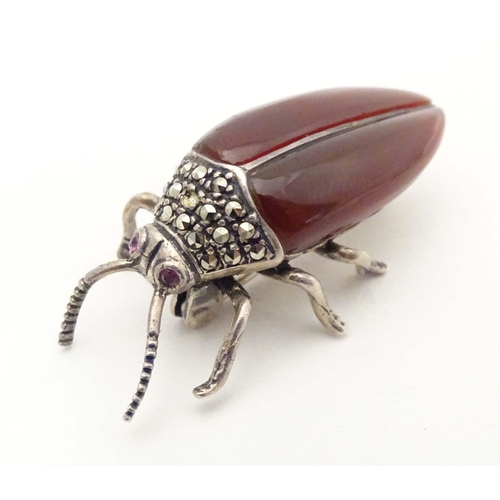 652 - A silver and white metal brooch formed as a beetle, with red stone eyes, marcasite detail and garnet... 