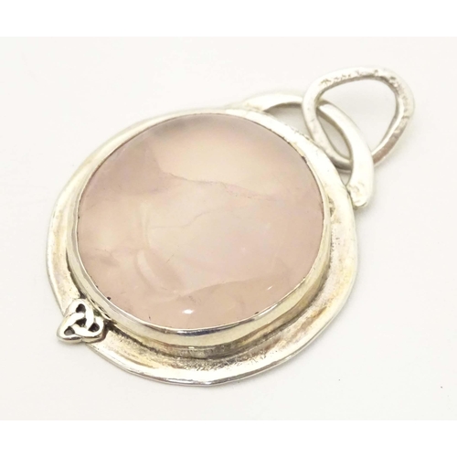 653 - A white metal pendant set wit rose quartz cabochon. Approx 1 1/2