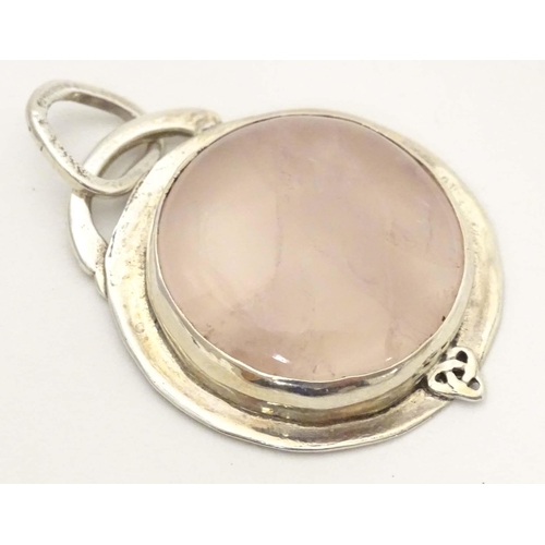 653 - A white metal pendant set wit rose quartz cabochon. Approx 1 1/2