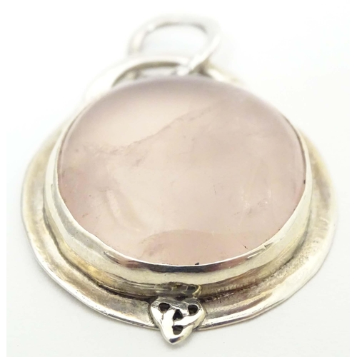 653 - A white metal pendant set wit rose quartz cabochon. Approx 1 1/2