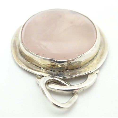 653 - A white metal pendant set wit rose quartz cabochon. Approx 1 1/2