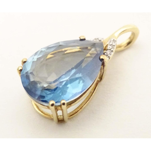 654 - A 9ct gold pendant set with blue topaz and diamonds. Approx 1