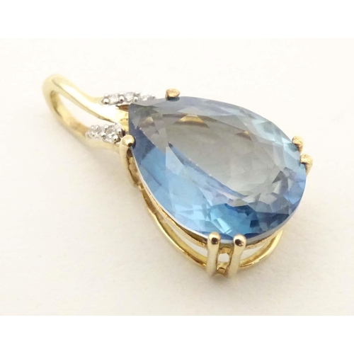 654 - A 9ct gold pendant set with blue topaz and diamonds. Approx 1