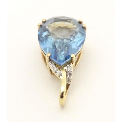 654 - A 9ct gold pendant set with blue topaz and diamonds. Approx 1