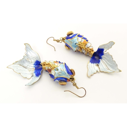 656 - A pair of drop earrings set with enamel and gilt decorated articulated fish. Approx. 3 3/4