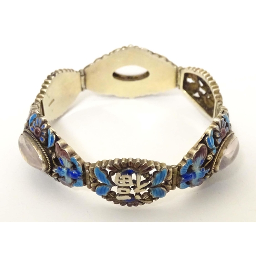 657 - A silver Oriental bracelet with enamel and cabochon detail. Approx. 7