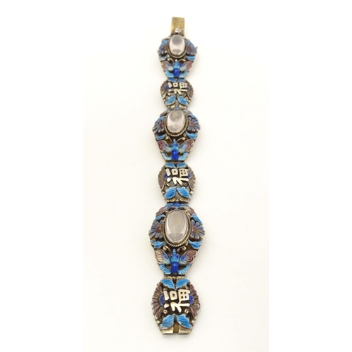 657 - A silver Oriental bracelet with enamel and cabochon detail. Approx. 7