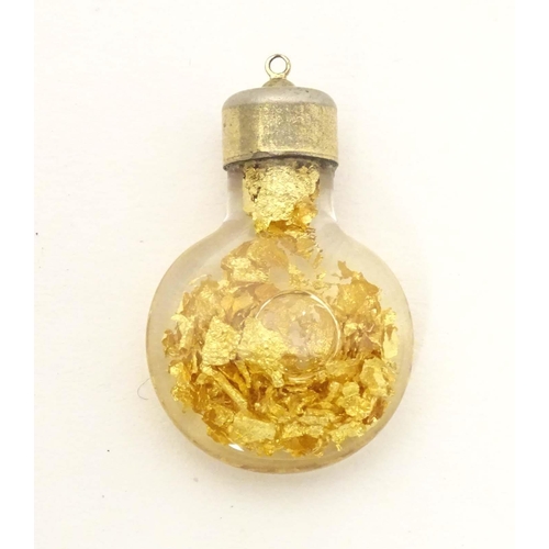 664 - A pendant charm formed as a bottle filled with gilt flecks. Approx. 1