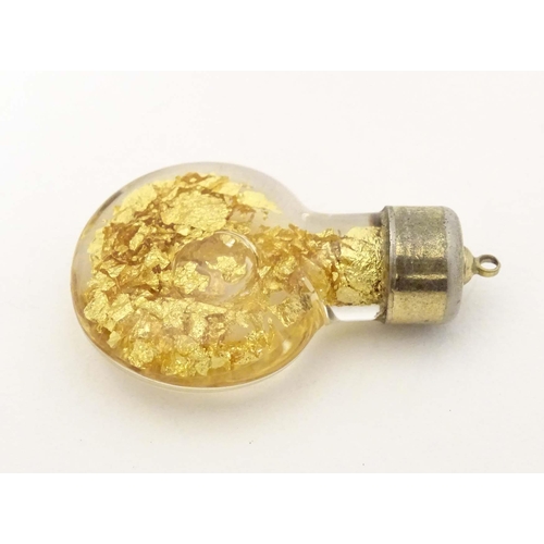 664 - A pendant charm formed as a bottle filled with gilt flecks. Approx. 1