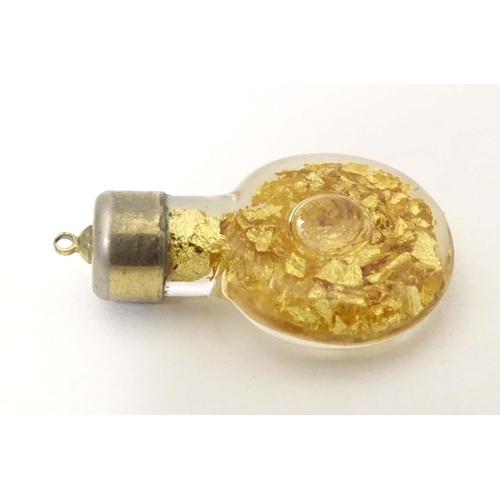 664 - A pendant charm formed as a bottle filled with gilt flecks. Approx. 1