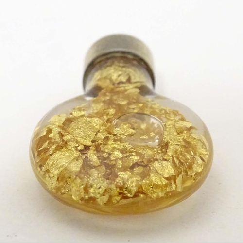 664 - A pendant charm formed as a bottle filled with gilt flecks. Approx. 1