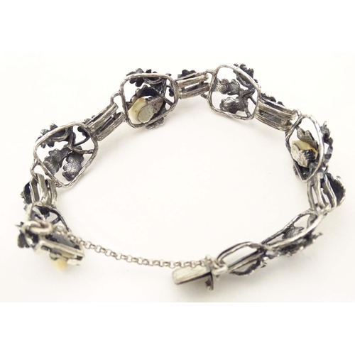 670 - A hunting trophy bracelet set with deer teeth within a white metal .800 silver mounts with oak leaf ... 