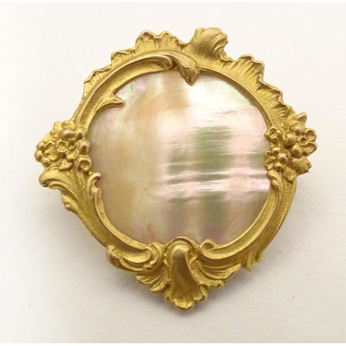 671 - A late 19th / early 20thC gilt metal brooch set with mother of pearl to centre. Approx. 1 1/4