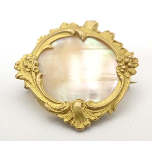 671 - A late 19th / early 20thC gilt metal brooch set with mother of pearl to centre. Approx. 1 1/4