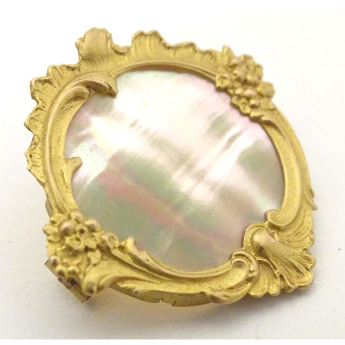 671 - A late 19th / early 20thC gilt metal brooch set with mother of pearl to centre. Approx. 1 1/4