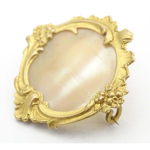 671 - A late 19th / early 20thC gilt metal brooch set with mother of pearl to centre. Approx. 1 1/4