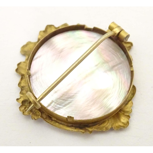 671 - A late 19th / early 20thC gilt metal brooch set with mother of pearl to centre. Approx. 1 1/4