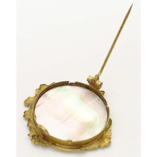 671 - A late 19th / early 20thC gilt metal brooch set with mother of pearl to centre. Approx. 1 1/4