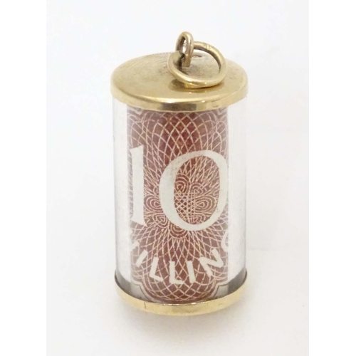 672 - A 9ct gold novelty pendant / charm of cylindrical form with rolled 10 shilling note to centre. Appro... 