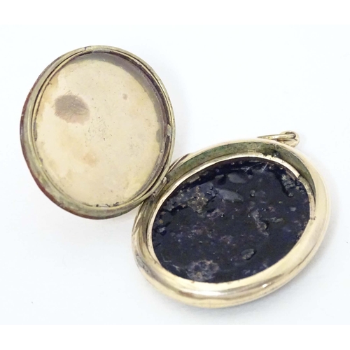 674 - Mourning / memorial jewellery: A Victorian yellow metal pendant locket of oval form with black ename... 