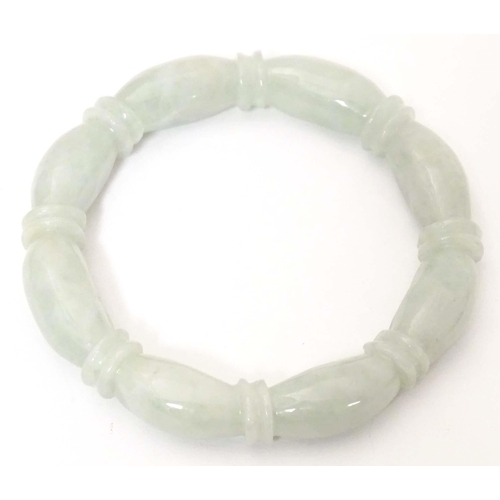 675 - A green jade bracelet of bangle form with carved detail.