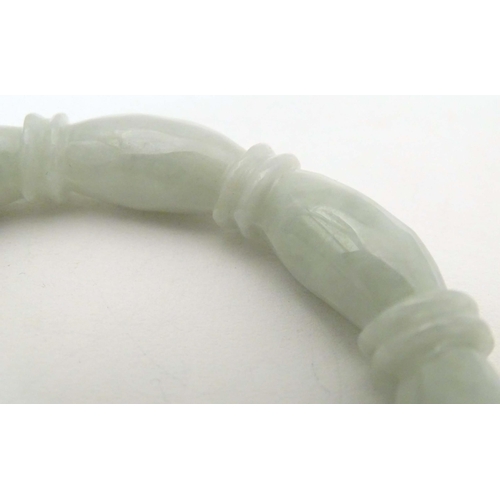 675 - A green jade bracelet of bangle form with carved detail.