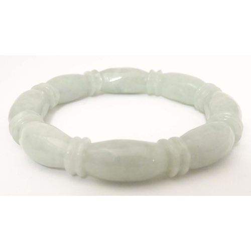 675 - A green jade bracelet of bangle form with carved detail.