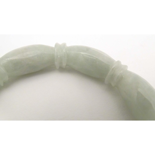 675 - A green jade bracelet of bangle form with carved detail.