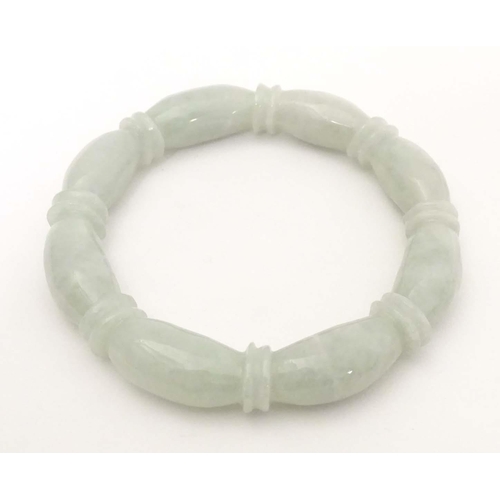 675 - A green jade bracelet of bangle form with carved detail.