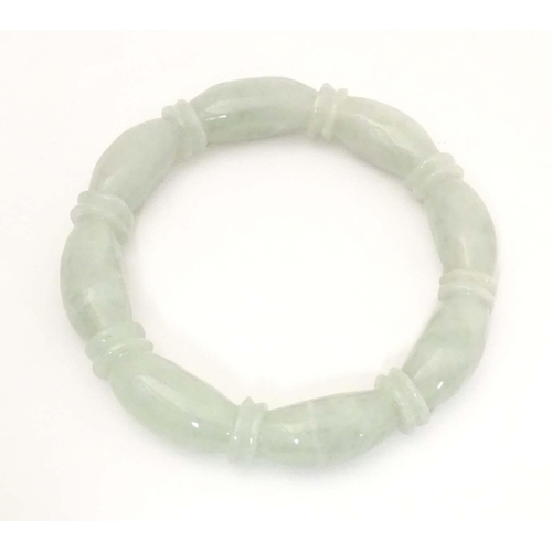 675 - A green jade bracelet of bangle form with carved detail.